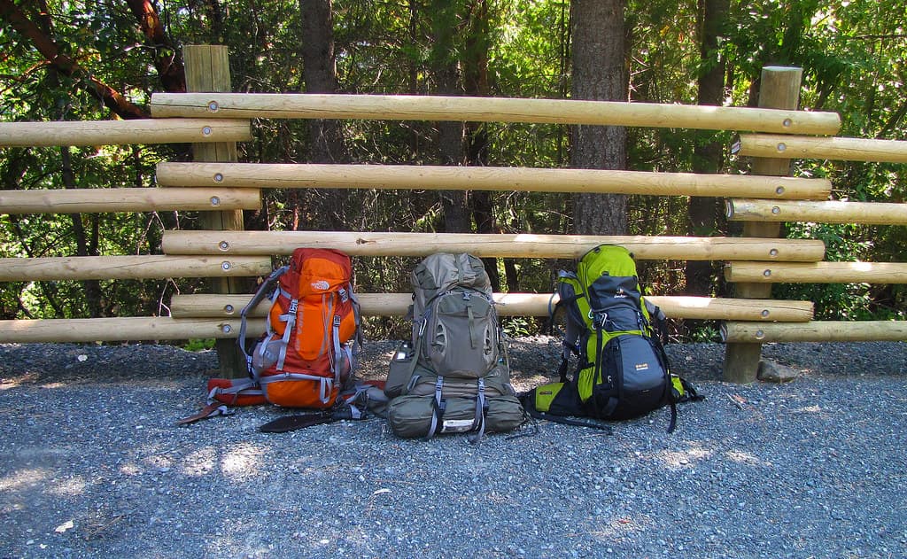 Three backpacks in forest road