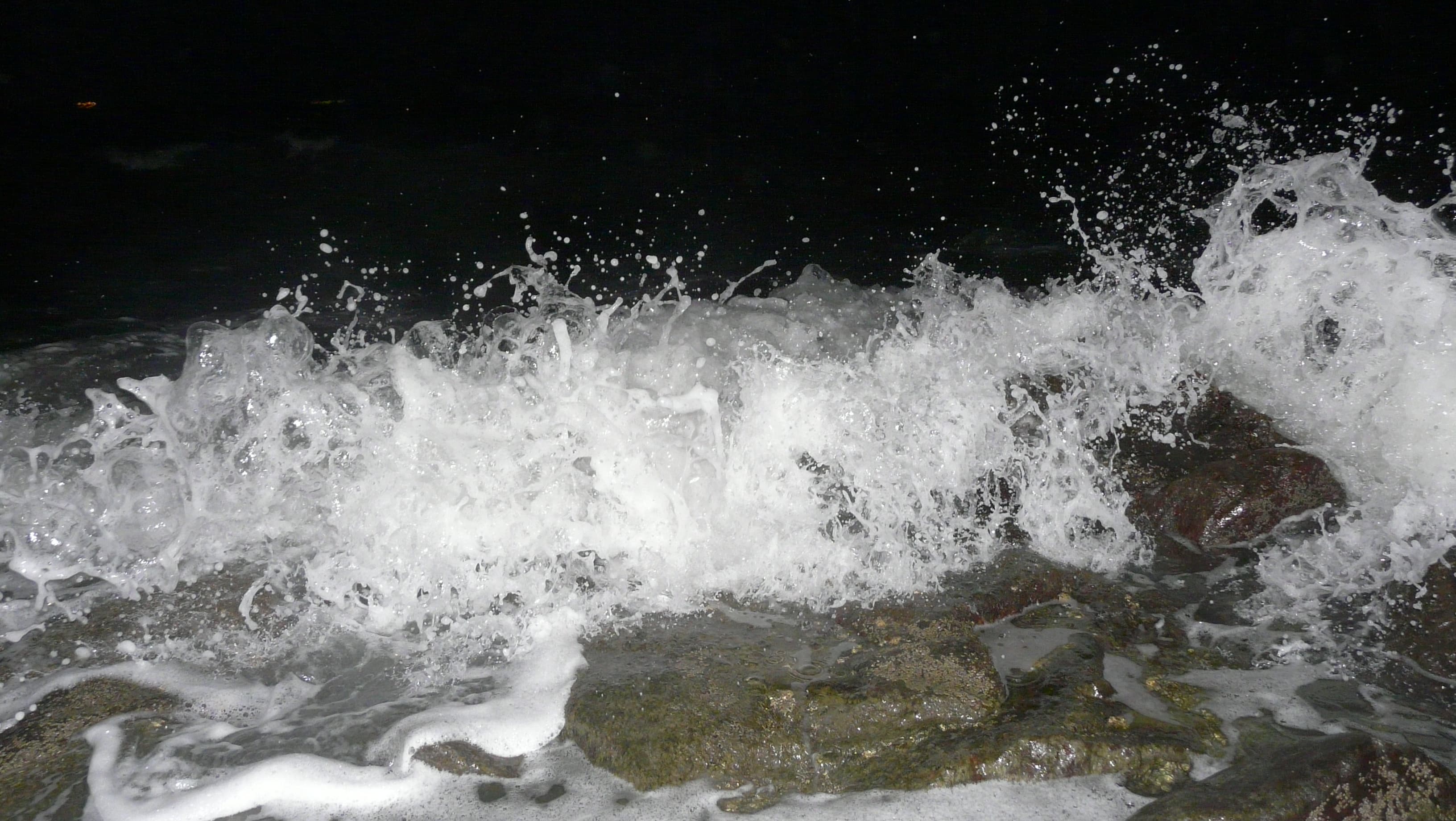 Beach waves rushing towards the rock in Panambur Beach