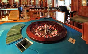 Tourists enjoying gaming tables on a casino cruise.