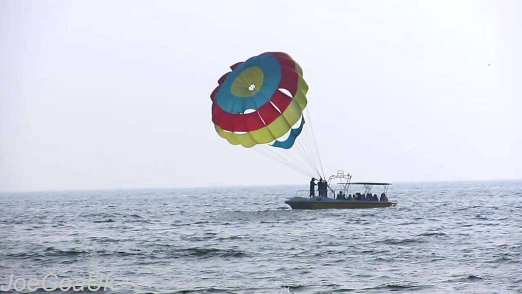 Parachutes gliding in the sky over Calangute Beach