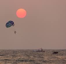 A parasailing gear against the sunset sky.