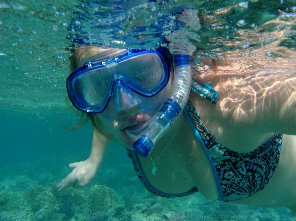 Tourists snorkeling in the crystal-clear waters of Grande Island