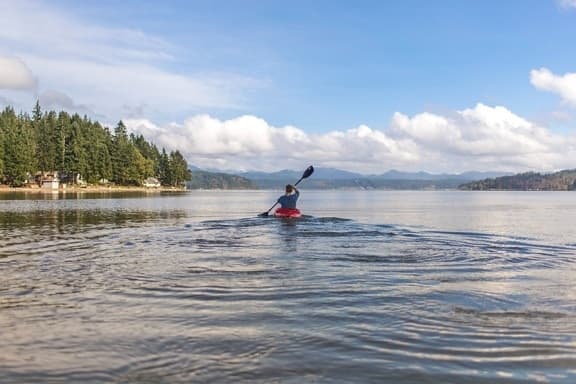 Kayakers gliding smoothly over the calm waters of Baga Creek