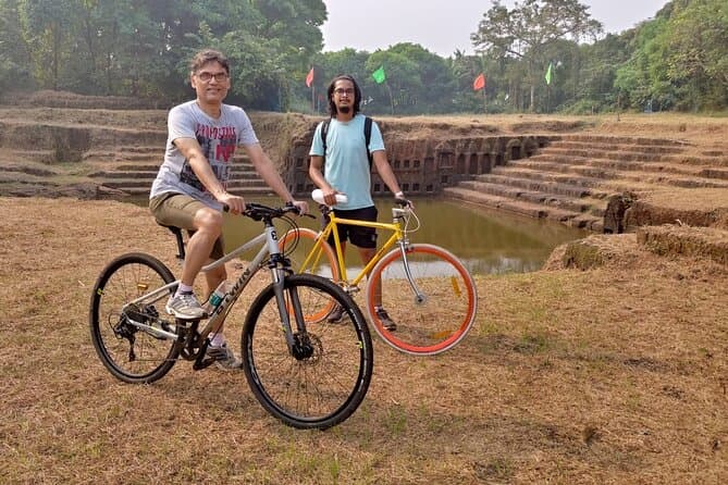 Tourists cycling past traditional Goan houses on Chorao Island