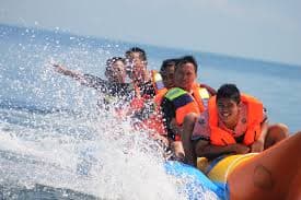 Sun-kissed beachgoers engaging in water sports at Baga