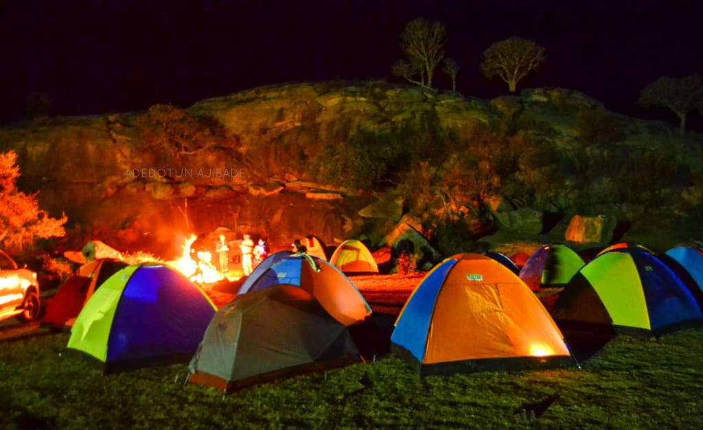 Campfire and tents under starry sky at Nandi Hills