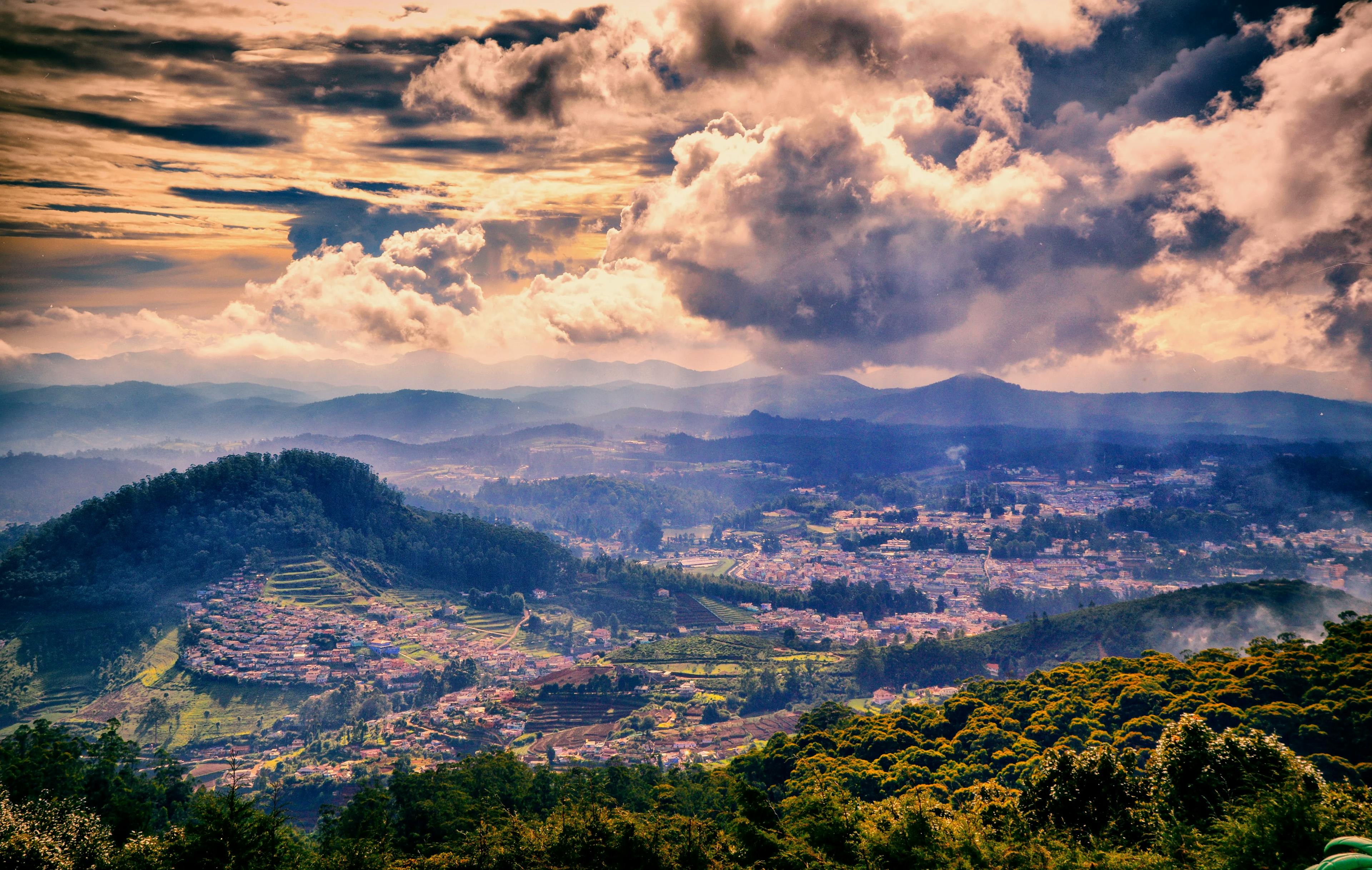 Cloudy Peaks Harmony: Ooty Backpacking Tour with Stunning Sunlit Village Scene